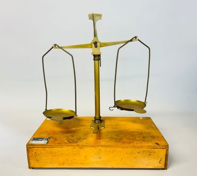 an old brass scale with two balance bars on it