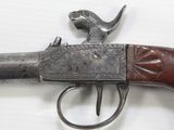 an old gun with a bird on top of it on a white surface