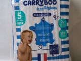 a baby in a diaper sitting on top of a blue and white striped diaper