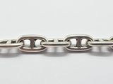 a close up of a silver chain on a white surface