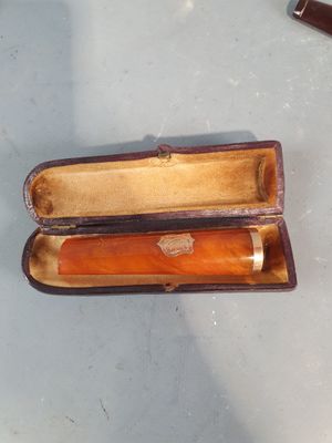 un étui marron contenant un stylo, posé sur une table