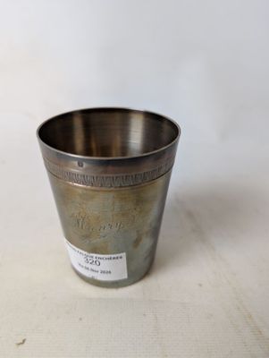 une vieille coupe en argent posée sur une table blanche