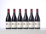 six bottles of red wine lined up in a row
