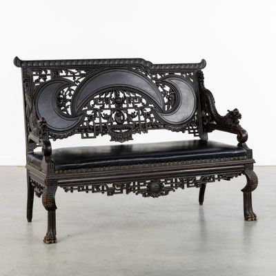 un banc noir posé sur un sol en béton