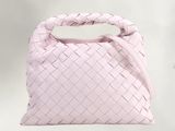 sac à main en cuir rose avec une anse tressée sur fond blanc
