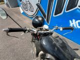 une moto garée devant un immeuble dont le mur est recouvert de graffitis