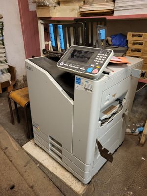 a printer that is sitting in a room next to a chair