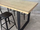 a wooden table with two black stools next to it