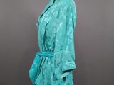 a mannequin mannequin wearing a turquoise jacket and skirt