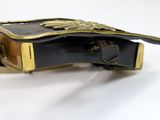 a black belt with a gold buckle on a white surface
