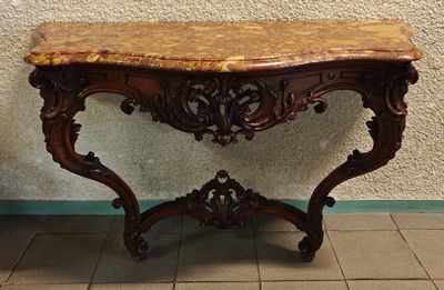 une table au plateau en marbre posée sur un sol carrelé, devant un mur