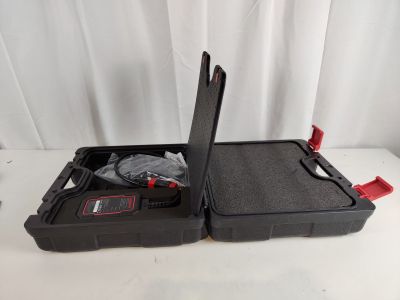an open black case with a red handle sitting on top of a white table