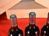 three bottles of wine sitting on a red table
