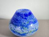 un vase en verre bleu et vert posé sur une table