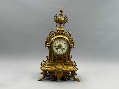 une horloge en or posée sur une table blanche