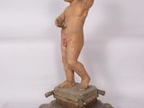a small statue of a baby standing on a pedestal