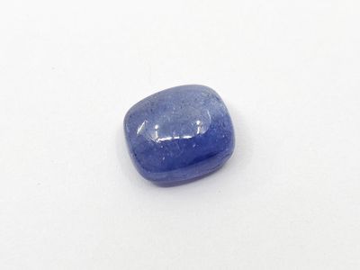 a close up of a blue sapphire stone on a white surface