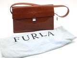 un porte-monnaie en cuir marron, avec un sac blanc à côté