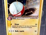 une carte Pokémon dans une boîte transparente posée sur une table