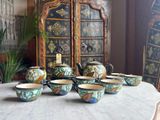 many bowls and cups sitting on a table with a cabinet in the background