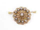 une image d'une broche en or et diamants sur fond blanc