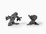 pair of bronze figurines of a boy and a girl on a white background