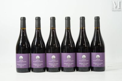 six bouteilles de vin sont alignées sur une surface blanche
