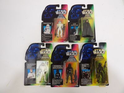 Six figurines de Star Wars sont alignées sur une surface blanche