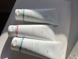 trois tubes de dentifrice posés sur une table à côté d'un miroir