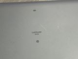 the back of a laptop computer sitting on top of a wooden table