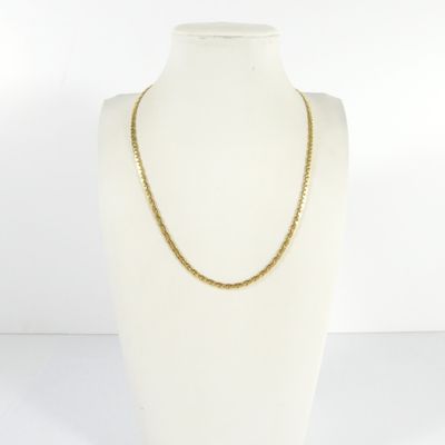 a white mannequin torso with a gold chain on it