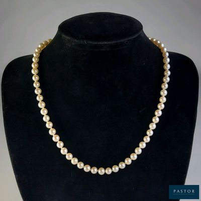un collier de perles blanches sur un mannequin noir