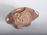 an image of a small bronze object on a white surface