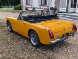a yellow sports car parked in front of a house