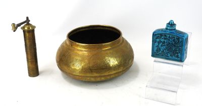 un vase en or et une bouteille en verre bleue placés l'un à côté de l'autre