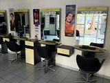 de nombreux fauteuils dans le salon, où les clients attendent de se faire couper les cheveux