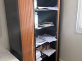 une armoire noire avec une porte en bois, dans un coin de la pièce