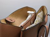 a brown purse with a tag on it sitting on a table