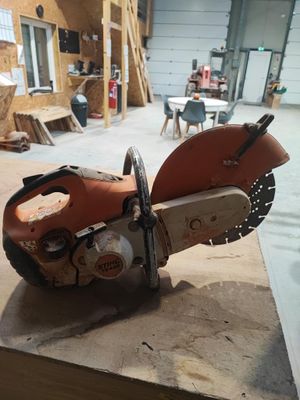 une tronçonneuse posée sur une table dans un atelier