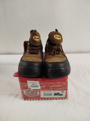 une paire de bottes de travail marron posée sur une boîte rouge