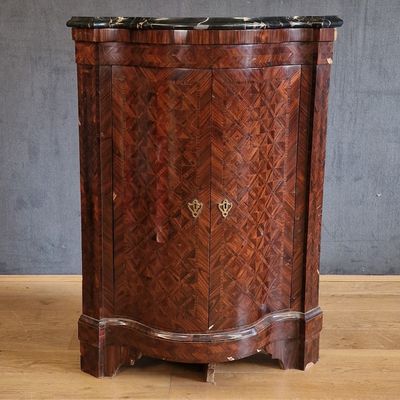a wooden cabinet with a marble top on a wooden floor