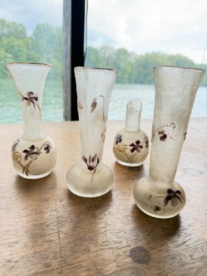 five glass vases sitting on a table next to a window