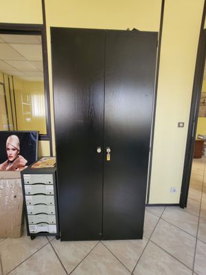 une photo d'un placard noir avec un miroir accroché au mur