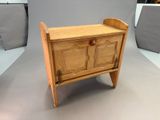 a small wooden chest with a drawer on it