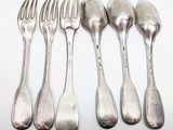 six silver spoons and a fork on a white surface