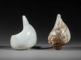 deux vases blancs posés l'un à côté de l'autre sur une surface grise