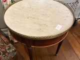 une table avec un plateau en marbre et une chaise dans un coin