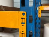 a blue and yellow shelf with some rolls of toilet paper on it