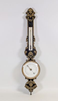 une horloge accrochée au mur, sur laquelle se trouve un baromètre