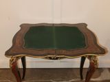 a small table with a green top and gold trim